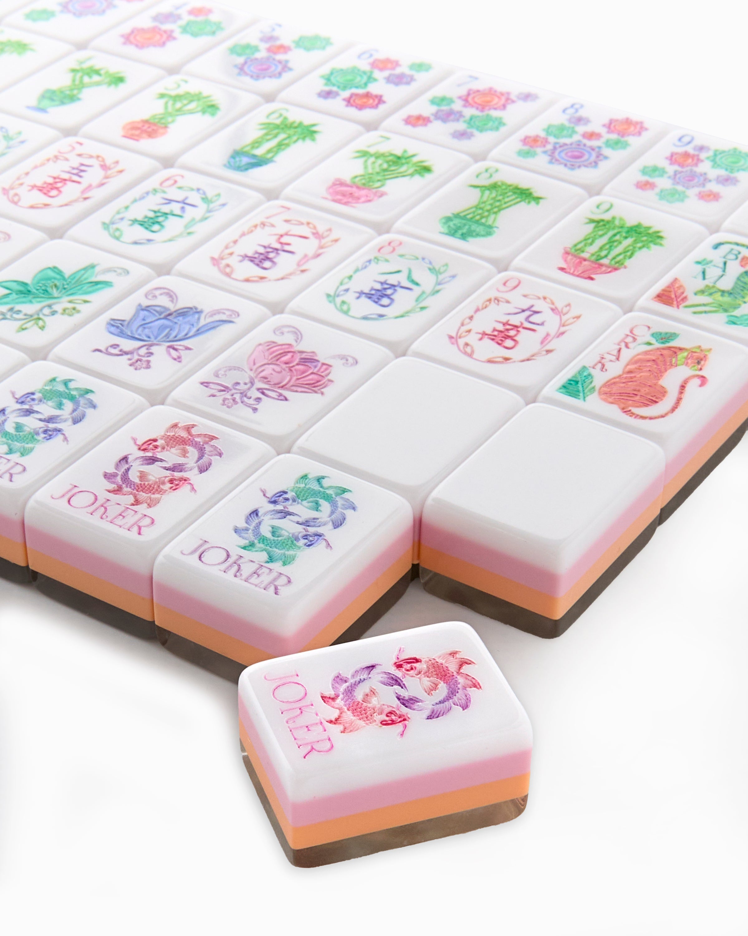 Colorful playing cards with floral designs and 'Joker' card on a white background