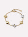 Gold and silver bracelet with heart and clover-shaped charms on a white background