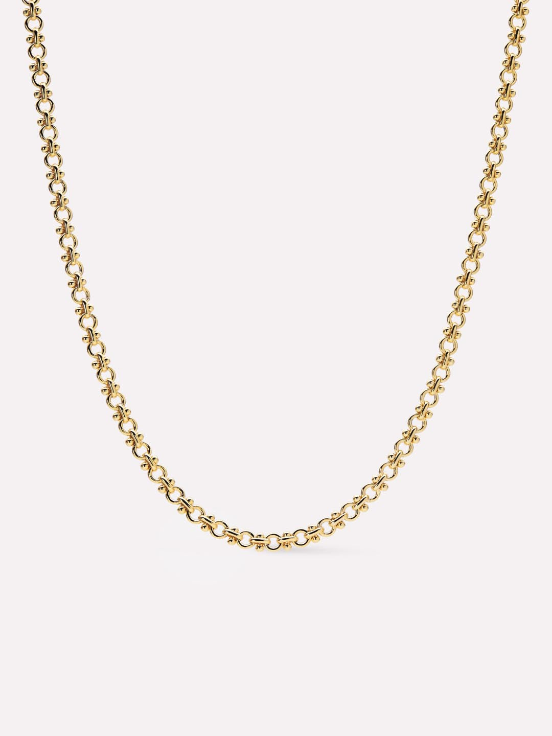 Gold chain necklace on a light beige background