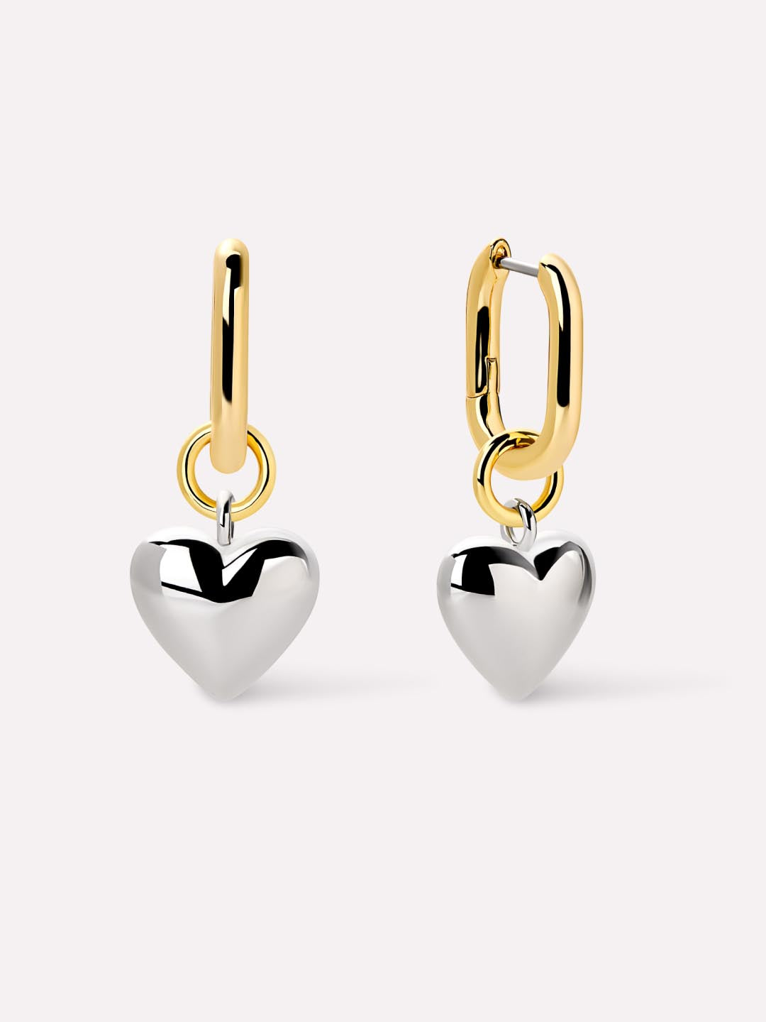 Gold hoop earrings with silver heart charms on a white background