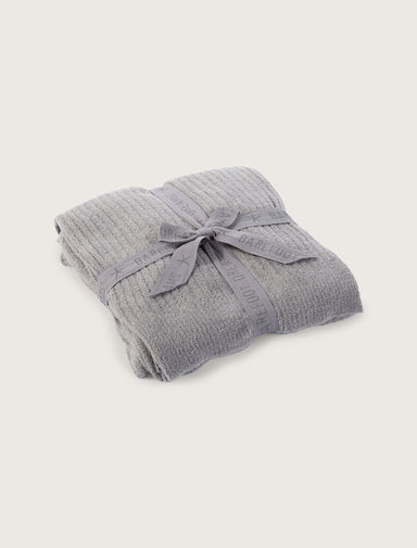 Folded gray textured blanket on a light gray background