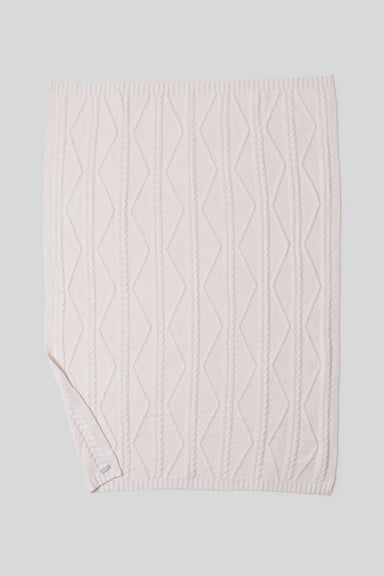 cream cable knit blanket on a light gray background