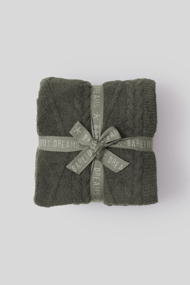 Folded dark green towel with 'Barefoot Dreams' branding on a white background