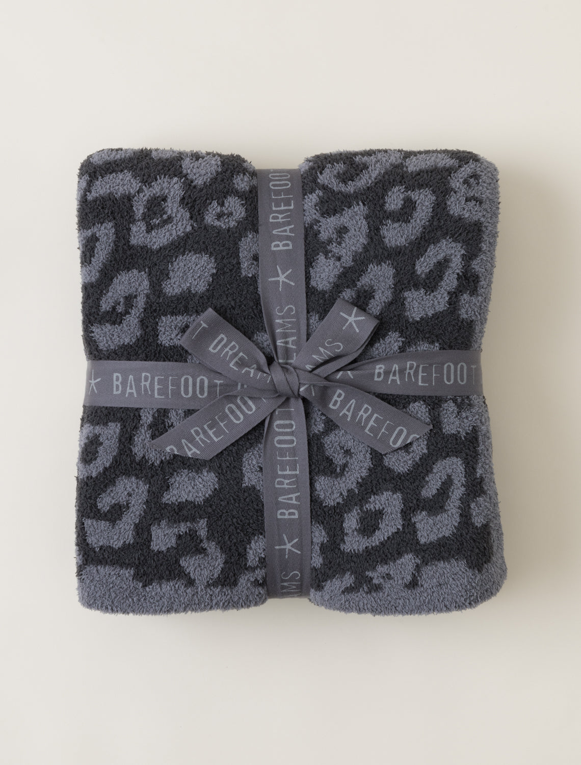 Folded towel with gray leopard print and Barefoot brand ribbon on a white background