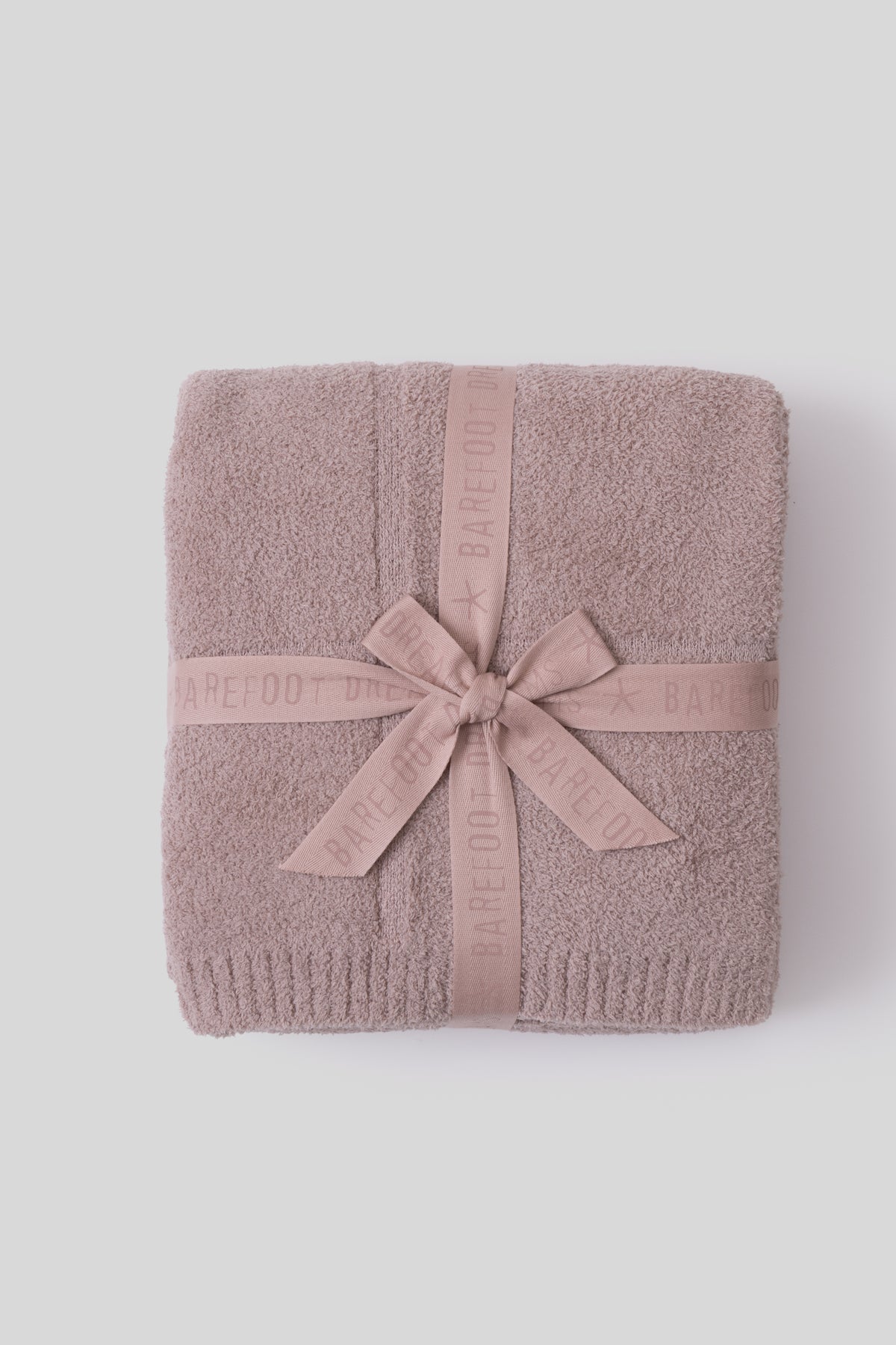 Folded towel with a pink ribbon on a white background
