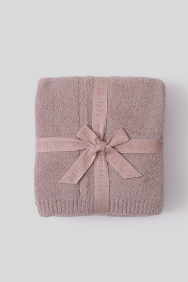 Folded towel with a pink ribbon on a white background