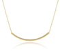 Gold necklace with a curved pendant on a white background