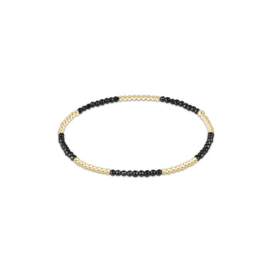 Bracelet with black beads and gold accents on a white background