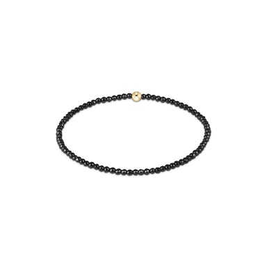 Black beaded bracelet with a gold clasp on a white background