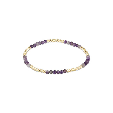 Beaded bracelet with purple and gold beads on a white background