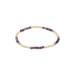 Beaded bracelet with purple and gold beads on a white background