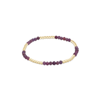 Bracelet with purple beads and gold accents on a white background