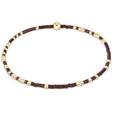 Bracelet with alternating brown and gold beads on a white background
