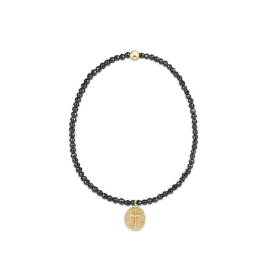 Black beaded necklace with a gold cross pendant on a white background