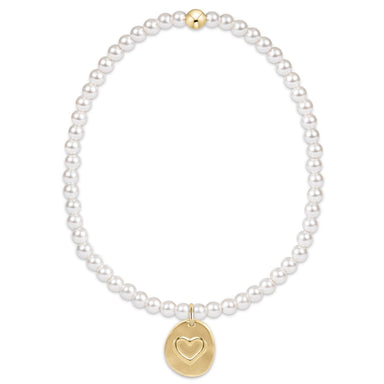 Pearl bracelet with a gold heart pendant on a white background