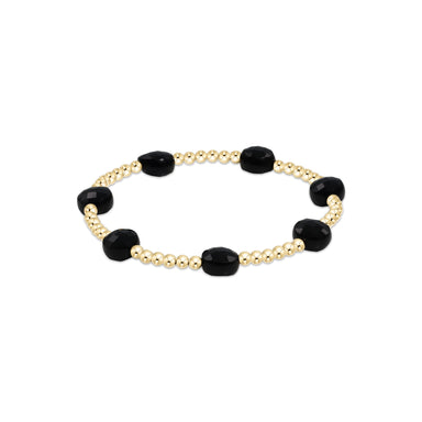 Bracelet with black beads and gold accents on a white background