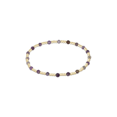 Bracelet with gold and purple beads on a white background