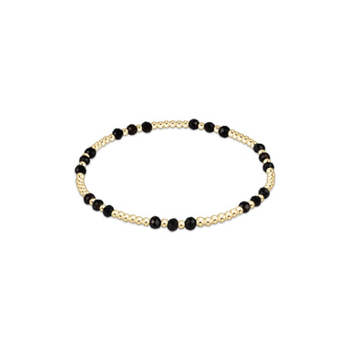 Bracelet with black beads and gold accents on a white background