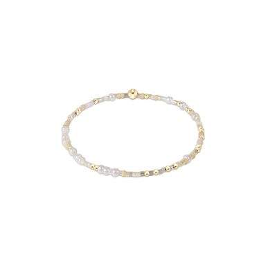 Delicate bracelet with gold and pearl beads on a white background
