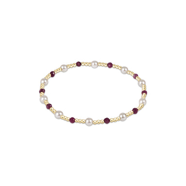 Bracelet with pearls and red gemstones on a white background