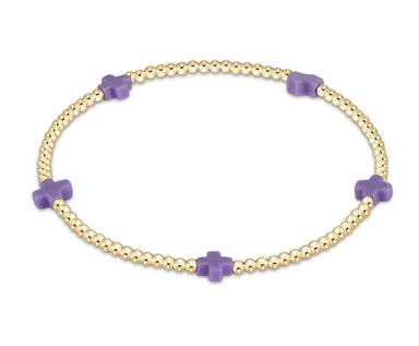 Gold bracelet with purple beads on a white background