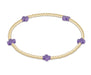 Gold bracelet with purple beads on a white background
