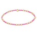 Pink beaded bracelet with gold beads on a white background