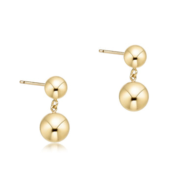 Pair of gold ball earrings on a white background