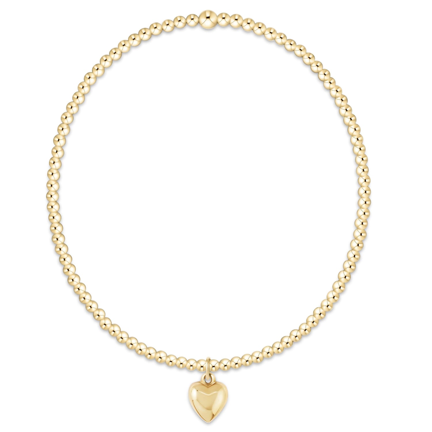 Gold beaded bracelet with a heart charm on a white background