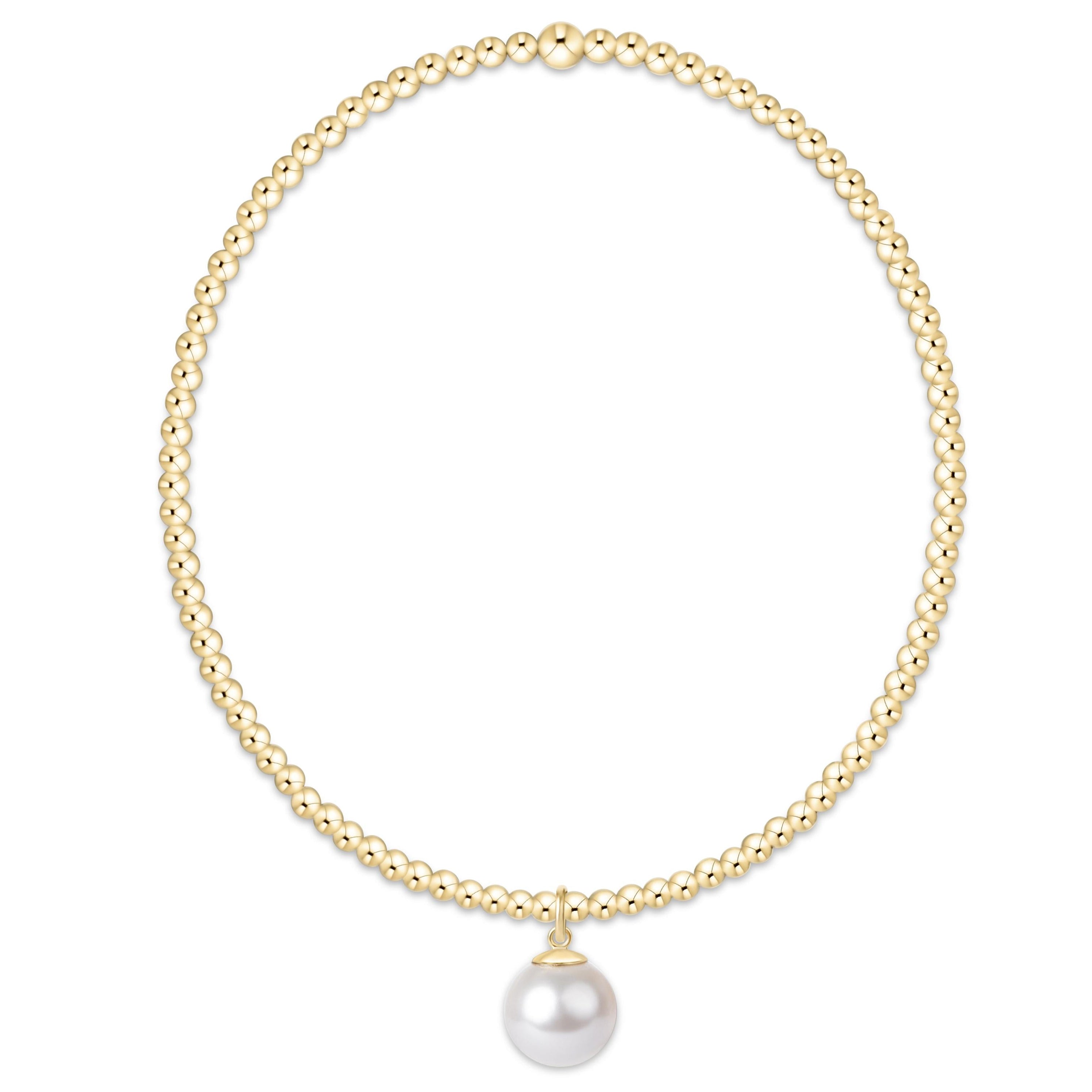 Gold necklace with a single pearl pendant on a white background