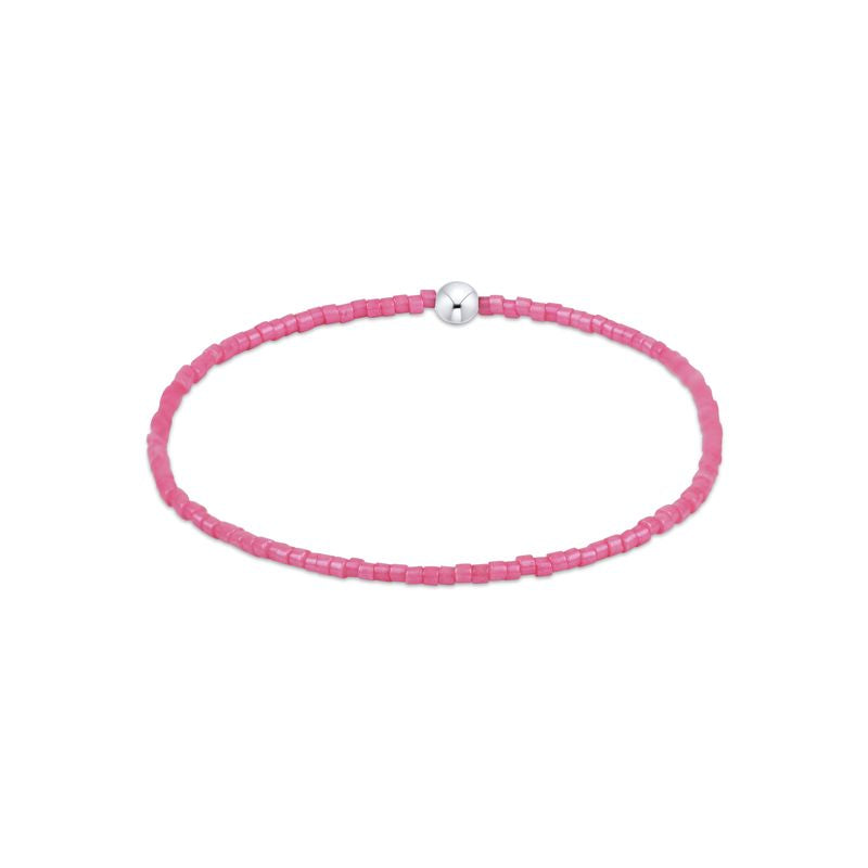 Pink beaded bracelet with a silver clasp on a white background