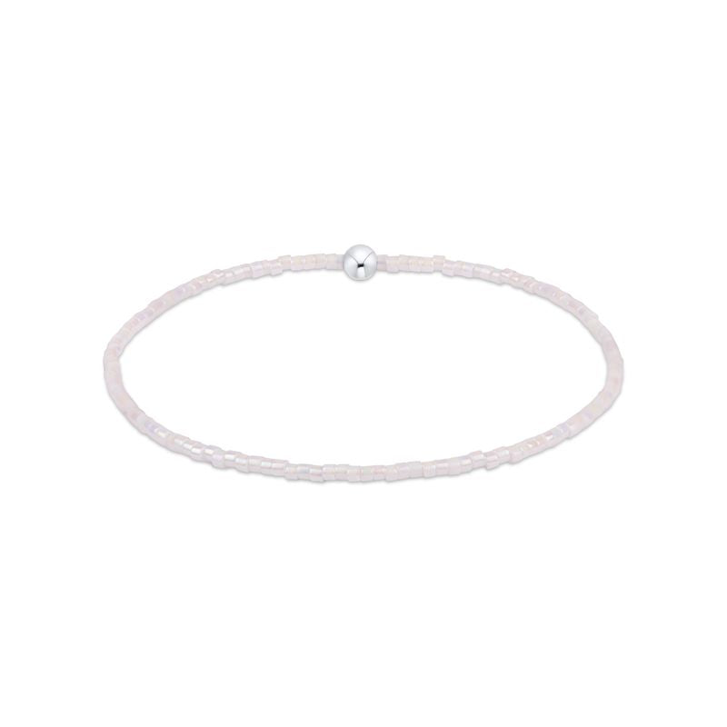 Silver bracelet with a single pearl on a white background