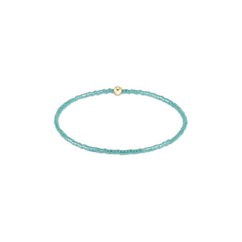 Turquoise beaded bracelet with a gold clasp on a white background