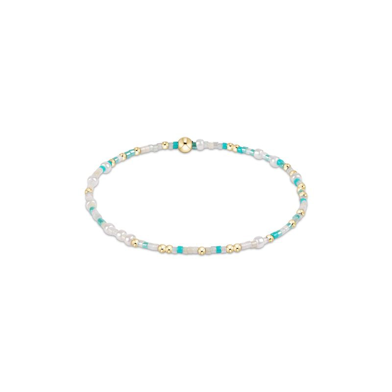 Beaded bracelet with white, blue, and gold beads on a white background