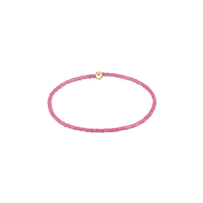 Pink beaded bracelet with a gold clasp on a white background