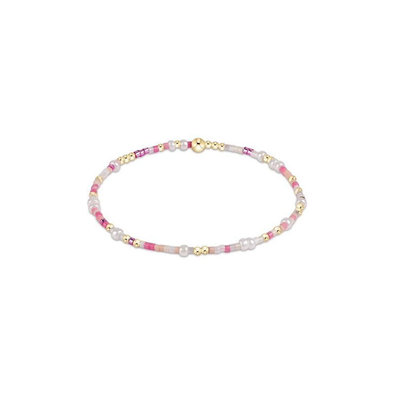Bracelet with pink, white, and gold beads on a white background