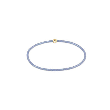 Thin lavender bracelet with a gold bead on a white background