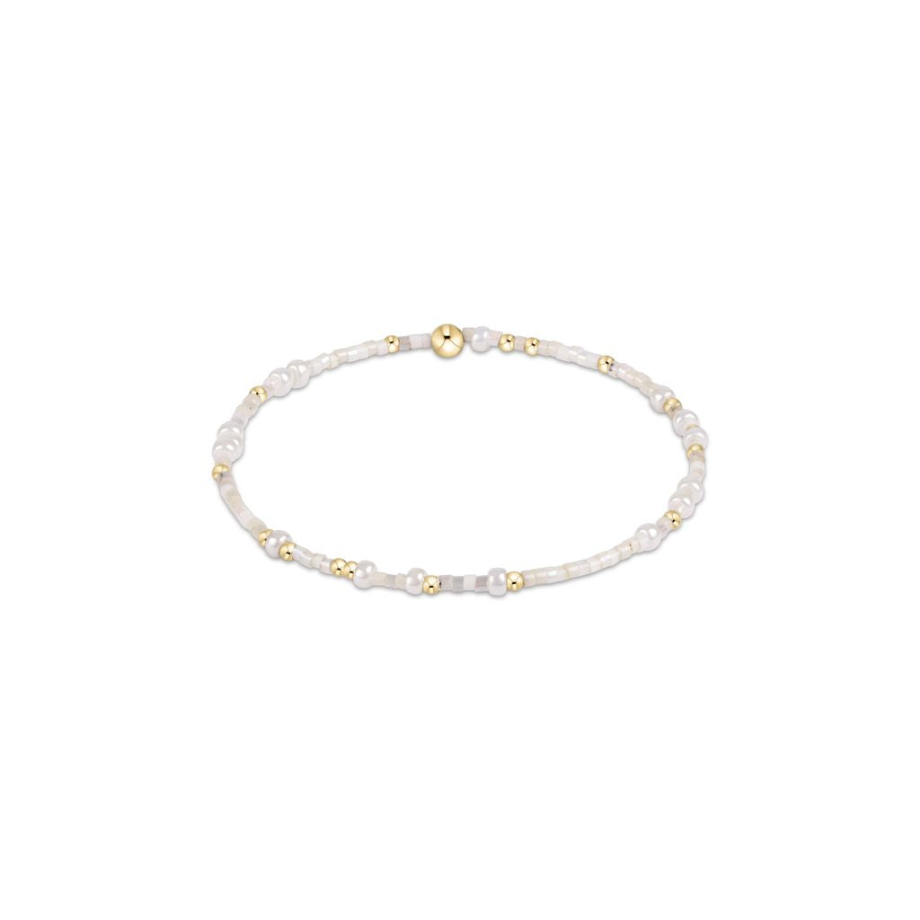Pearl bracelet with gold beads on a white background