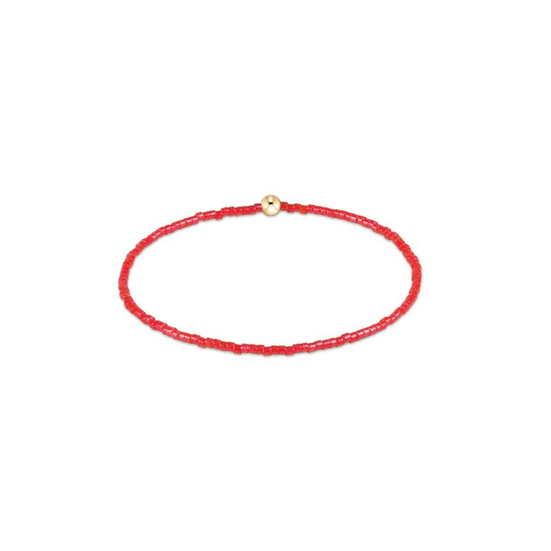 Red beaded bracelet with a gold clasp on a white background