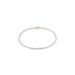 Thin white beaded bracelet with a gold clasp on a white background