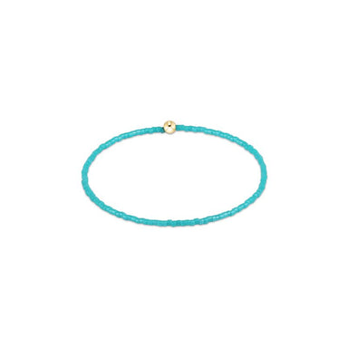 Turquoise beaded bracelet with a gold clasp on a white background