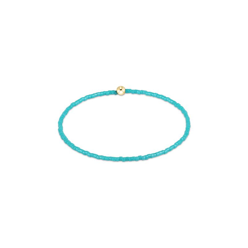 Turquoise beaded bracelet with a gold clasp on a white background
