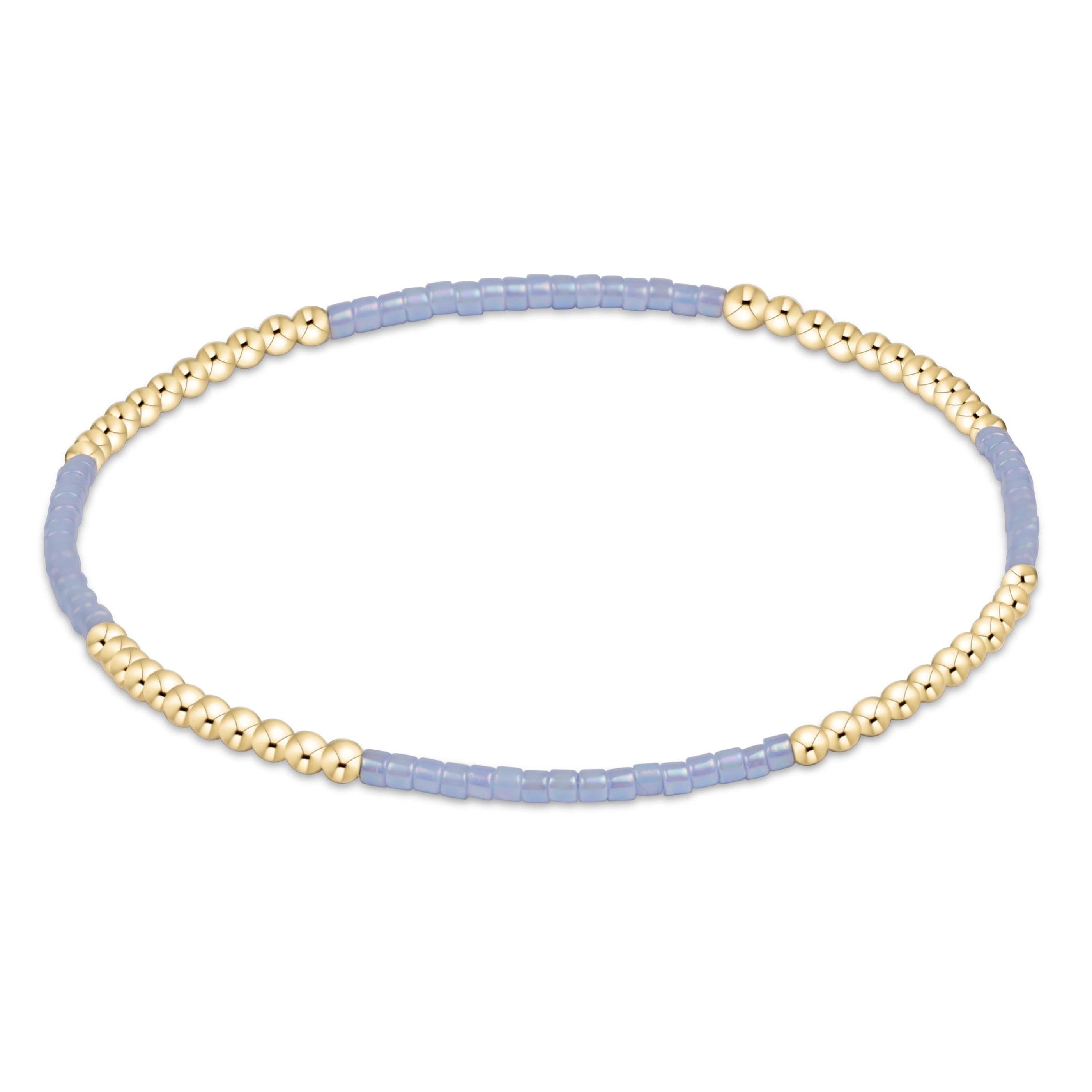 Bracelet with gold beads and light purple beaded strands on a white background