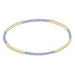 Bracelet with gold beads and light purple beaded strands on a white background