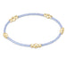 Bracelet with gold beads on a light purple cord against a white background
