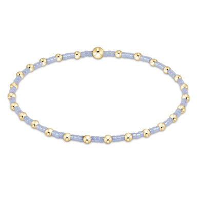 Bracelet with gold and light blue beads on a white background