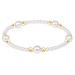 Pearl bracelet with gold beads on a green background