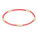 Bracelet with red beads and gold accents on a white background