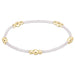 White bracelet with gold beads on a white background