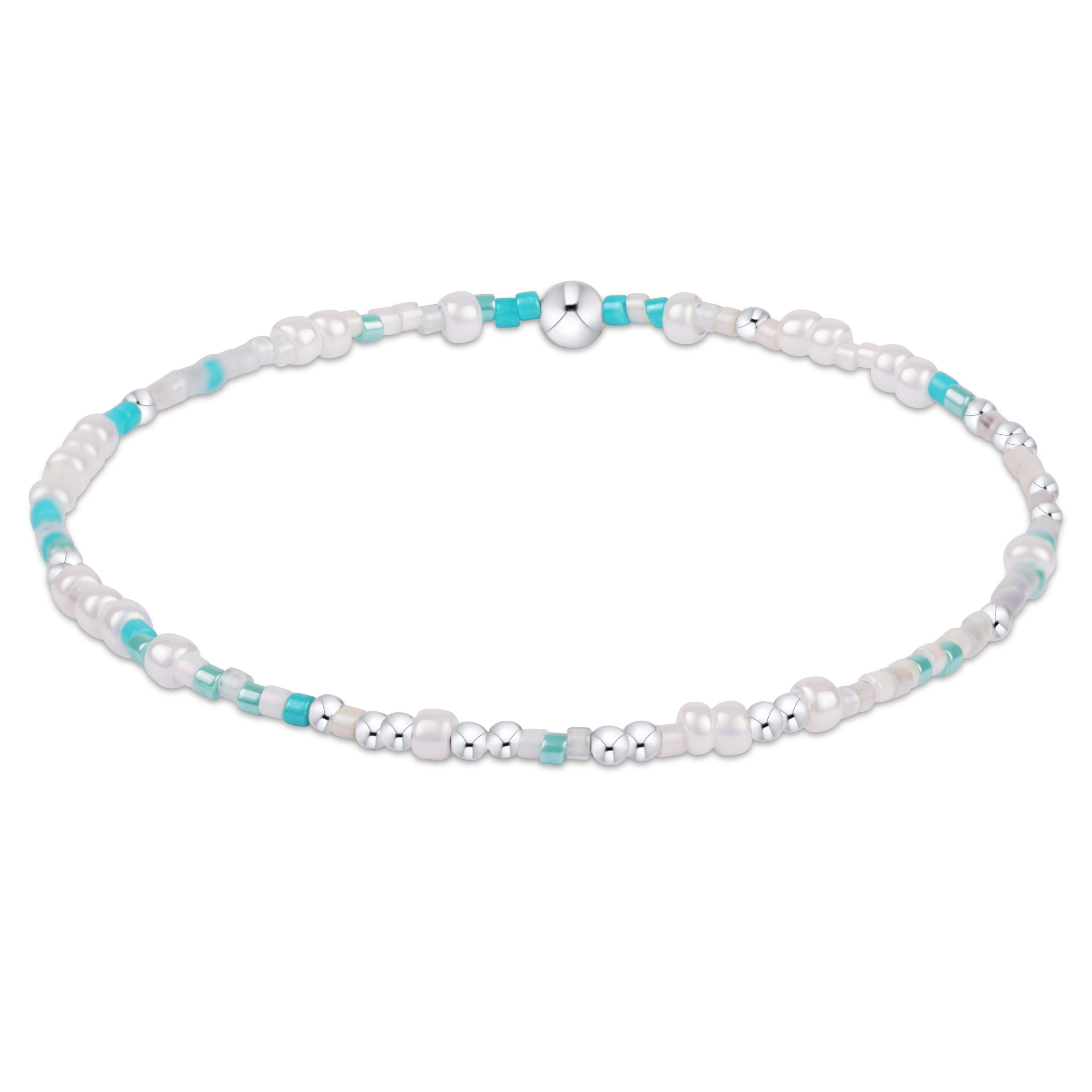 Bracelet with white beads and turquoise accents on a white background